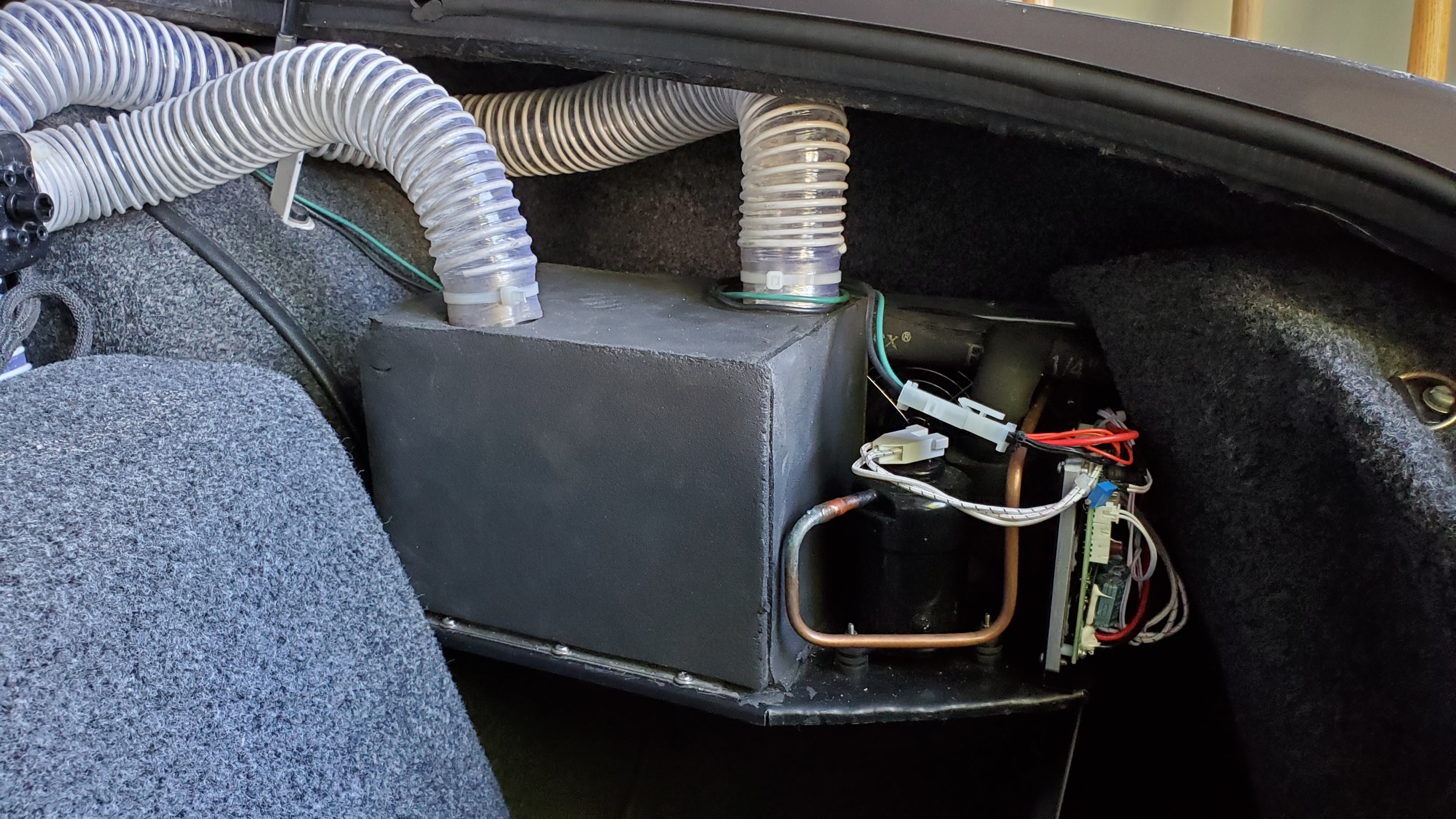 Micro DC Aircon module and air hoses installed in a vehicle compartment