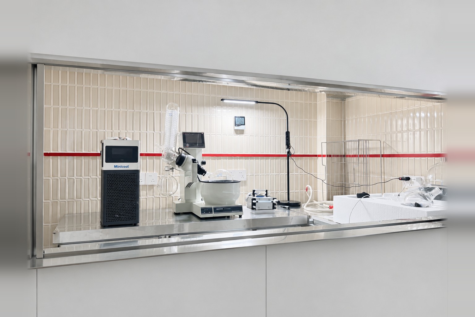 MiniCool recirculating chiller beside rotary evaporator glassware inside a laboratory fume hood