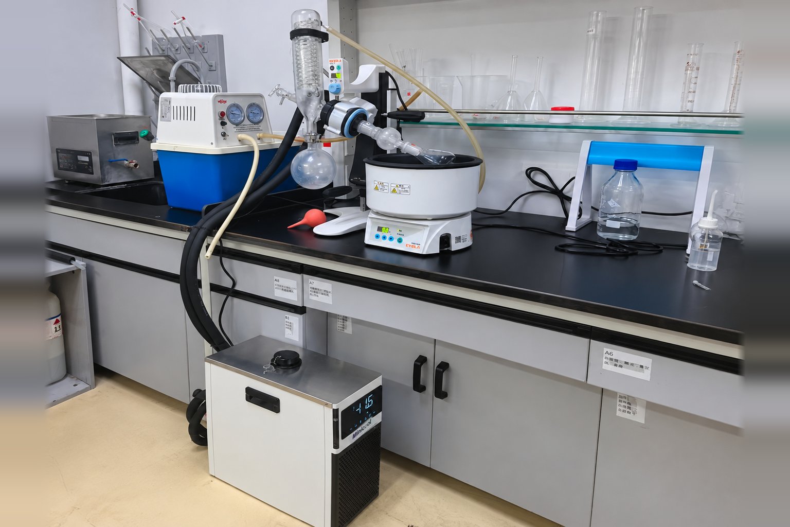MiniCool recirculating chiller under a laboratory bench with coolant hoses running up to the bench top