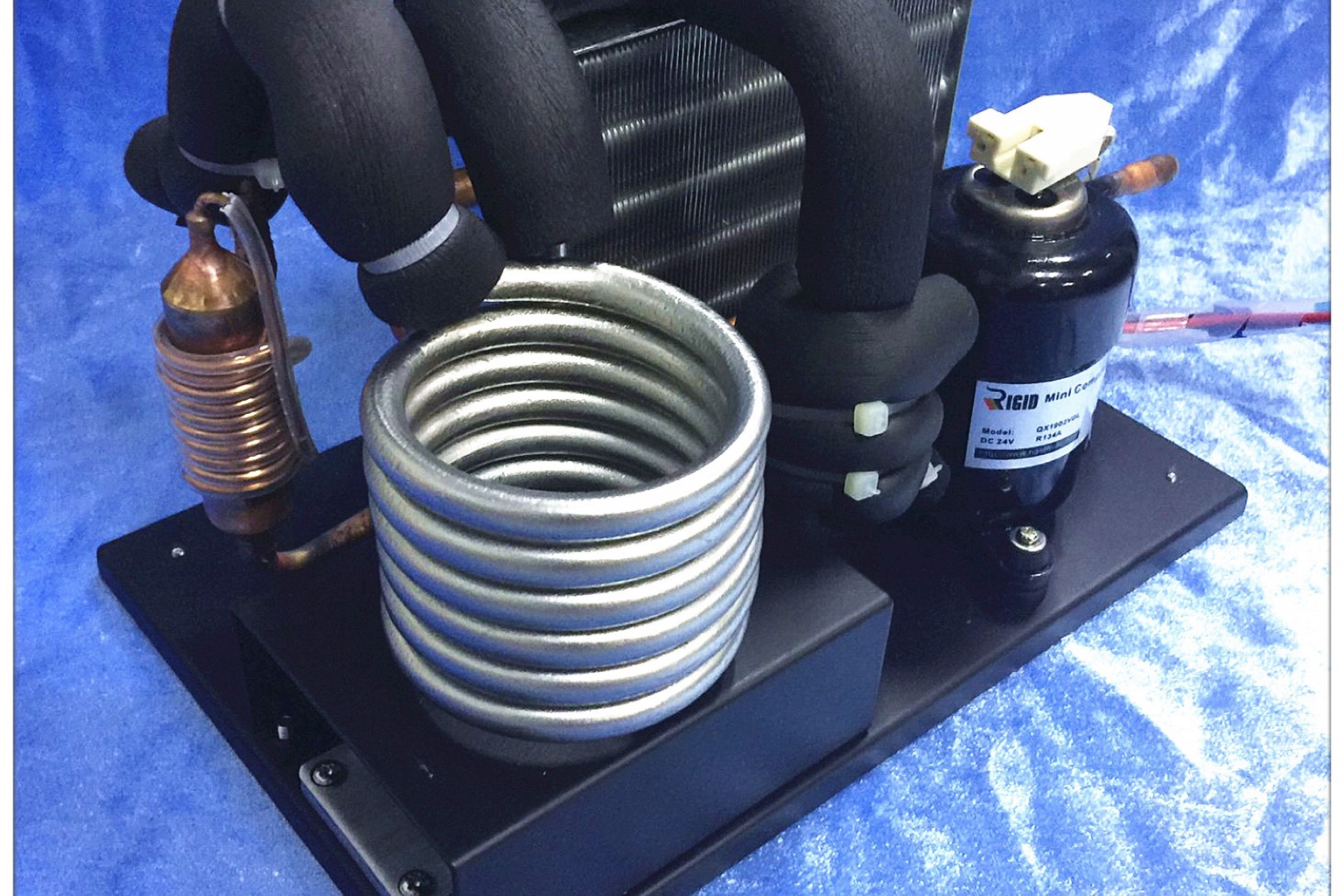 Plate liquid chiller module showing compressor, condenser and water connections on a base plate