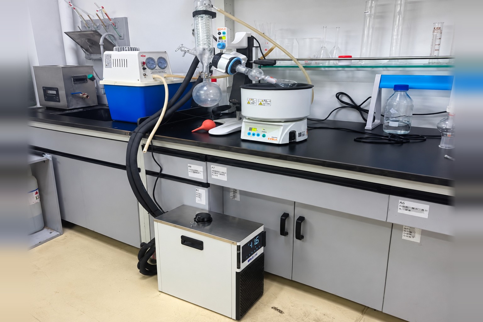 Compact recirculating chiller on a laboratory floor below a bench-top rotary evaporator