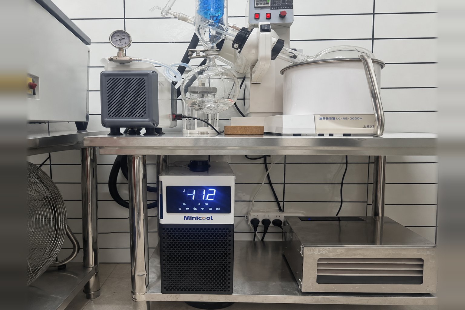 MiniCool recirculating chiller under a stainless laboratory bench below a rotary evaporator