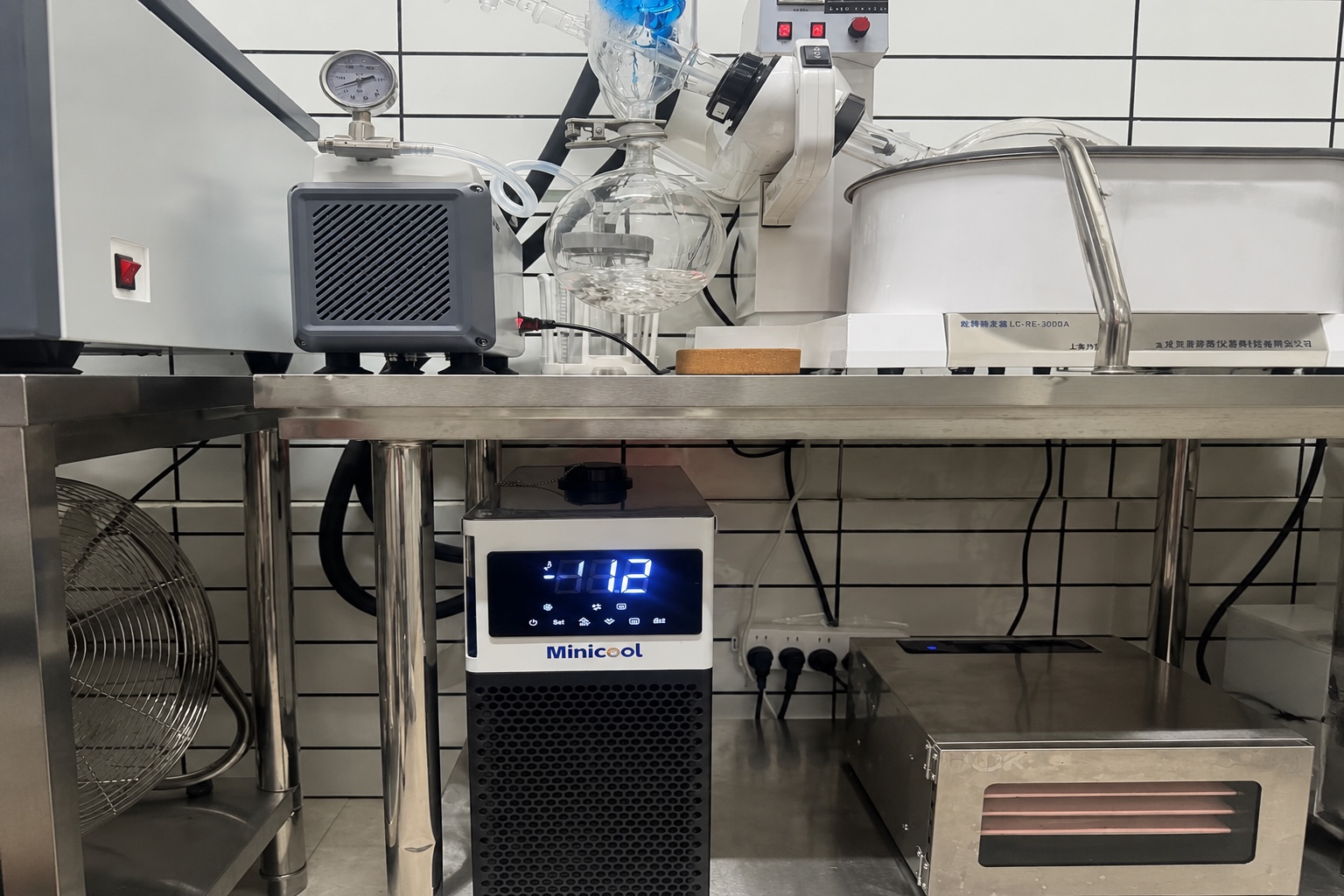 MiniCool countertop recirculating liquid chiller installed beneath a laboratory bench serving a rotary evaporator