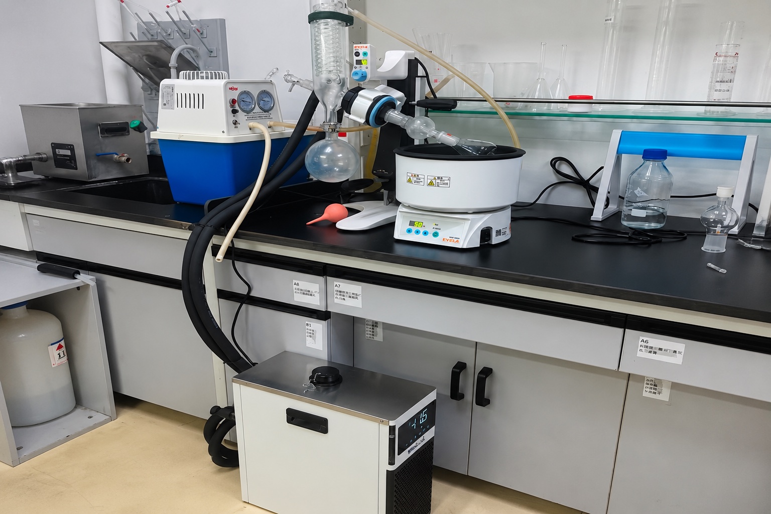 Compact liquid chiller with insulated hoses feeding a laboratory instrument